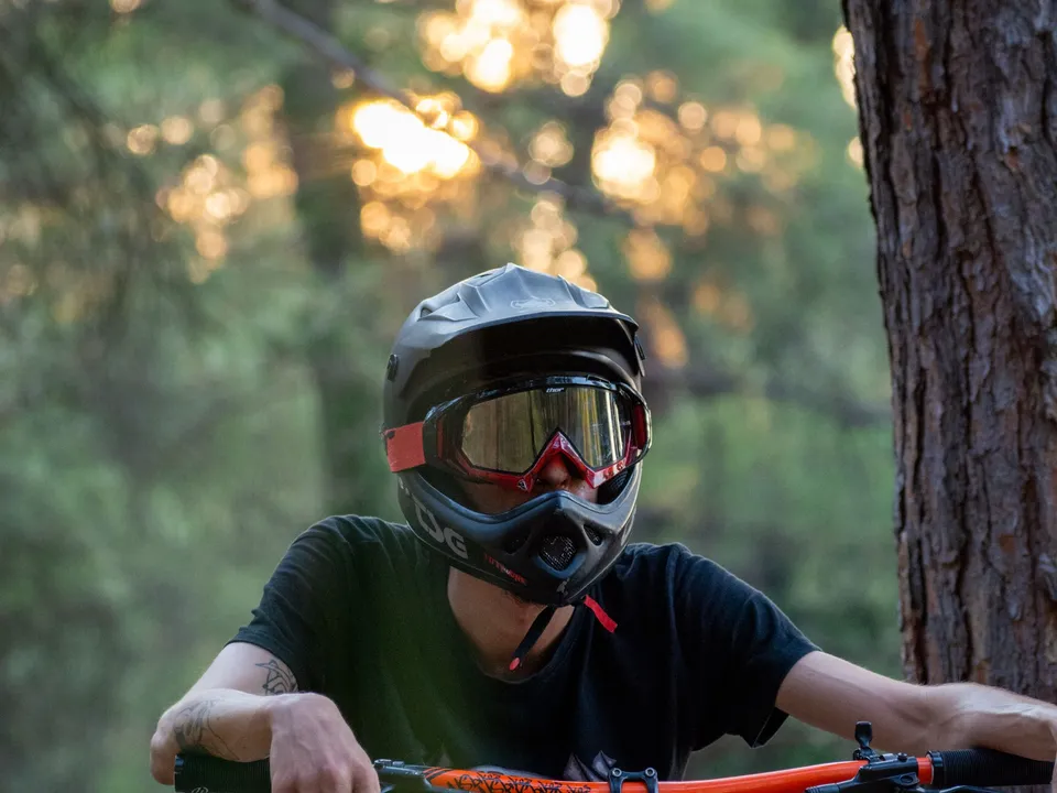 Vététiste portant un casque intégral et un masque dans une forêt